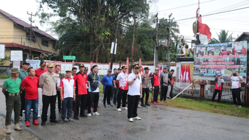 Dr. Gutmen Membagikan Sekaligus Mengibarkan Bendera Merah Putih di Tugu Pahlawan Ngabang