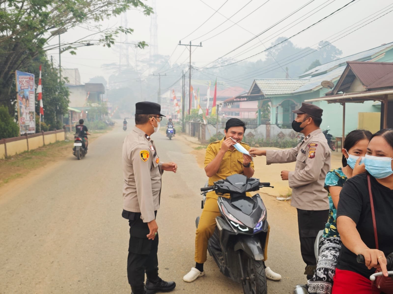 “Kabut Asap Selimuti Sengah Temila, Polisi Turun Tangan Bagikan Masker kepada Warga”