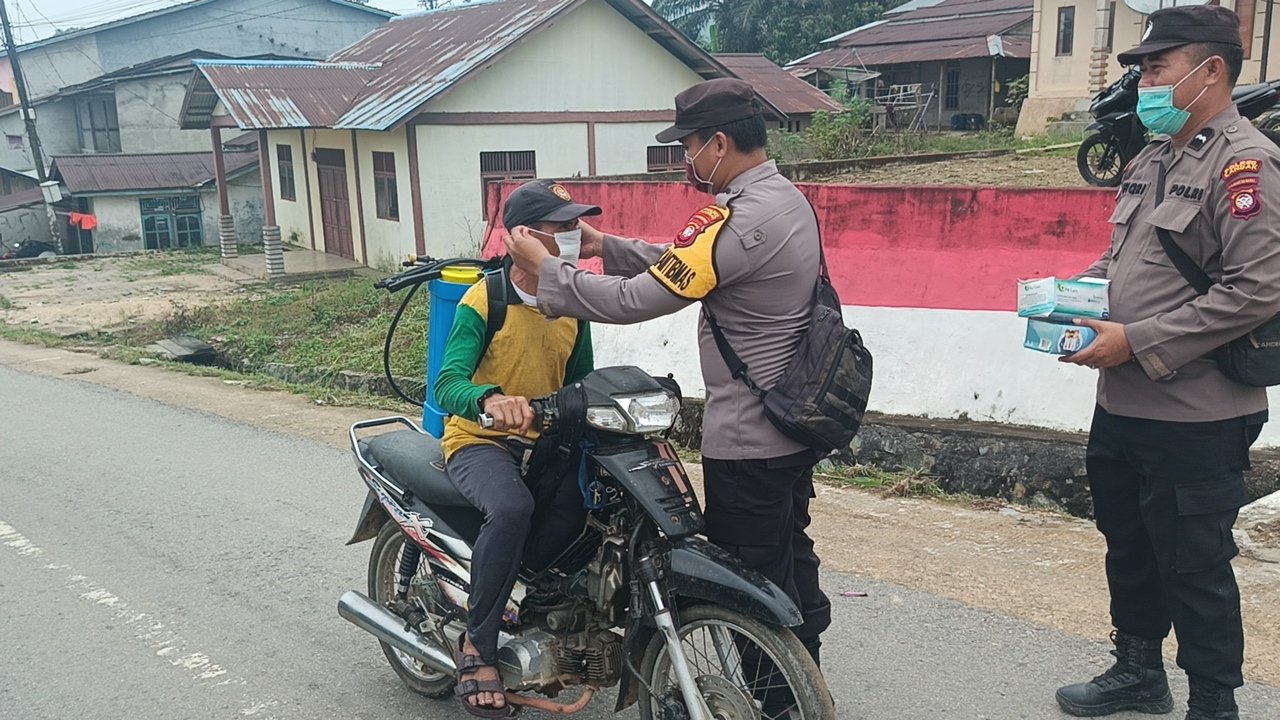 PERKUAT SINERGITAS CEGAH KARHUTLA, KAPOLSEK MEMPAWAH HULU CEK POSKO DAN BAGIKAN MASKER KEPADA MASYARAKAT